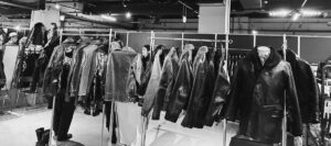 レザージャケットが整然と並ぶ展示ブース。来場者が製品を見比べている様子。