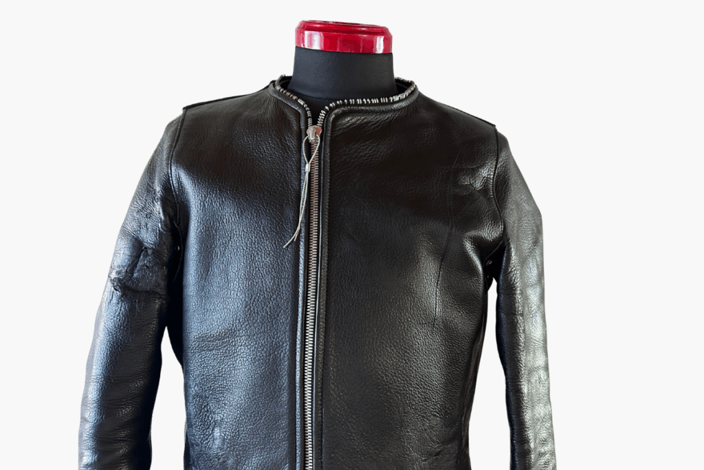 N.HOOLYWOOD(エヌハリウッド)のノーカラーライダースジャケット。シボ感のあるレザーとミニマルなデザインが特徴。